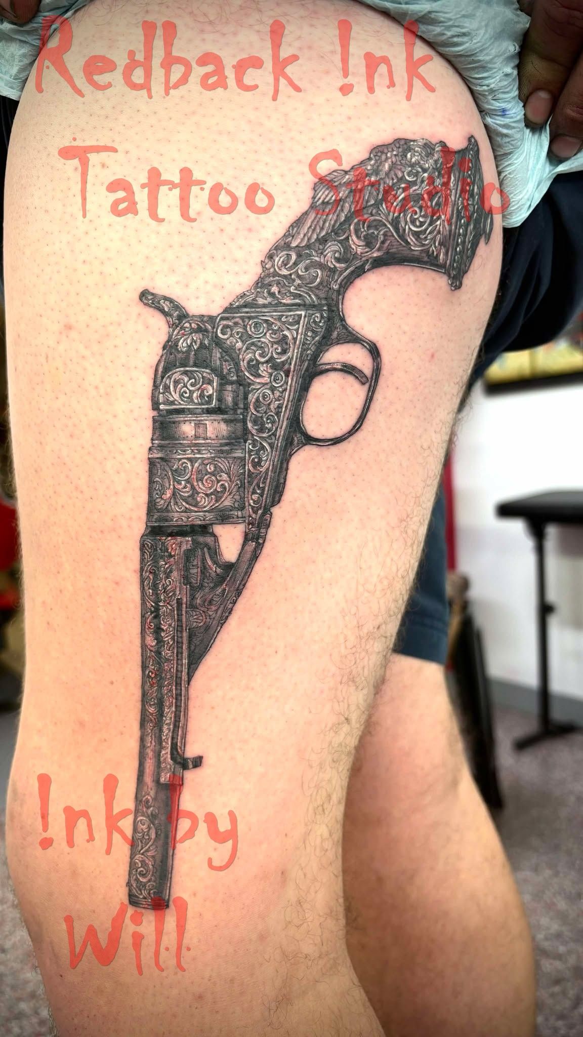 Tattoo of an ornate pistol on a person's thigh. Redback Ink Tattoo Shop & 