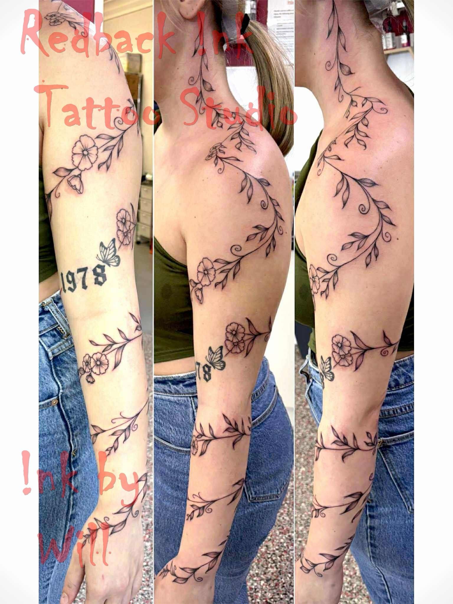 Woman with a floral vine tattoo up her arm, with the year 