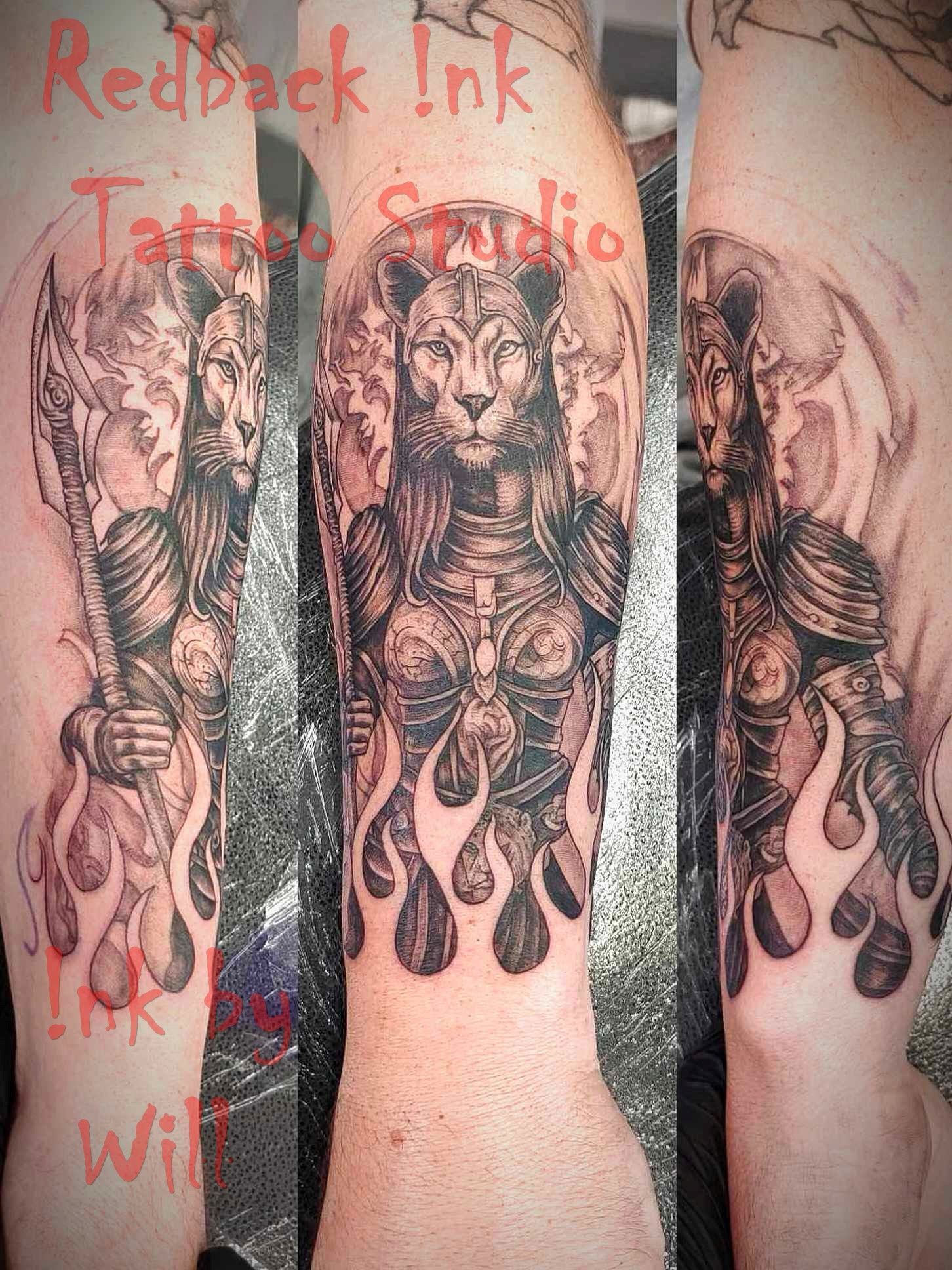 Tattoo of a lioness warrior in armor with flames. Redback Ink studio text.