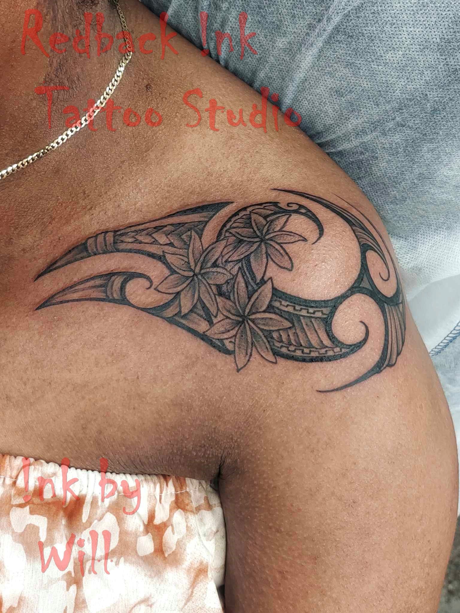 Tattoo on shoulder featuring Polynesian patterns and flowers, done at a tattoo studio — Redback !nk Tattoo Studio in Kawana, QLD