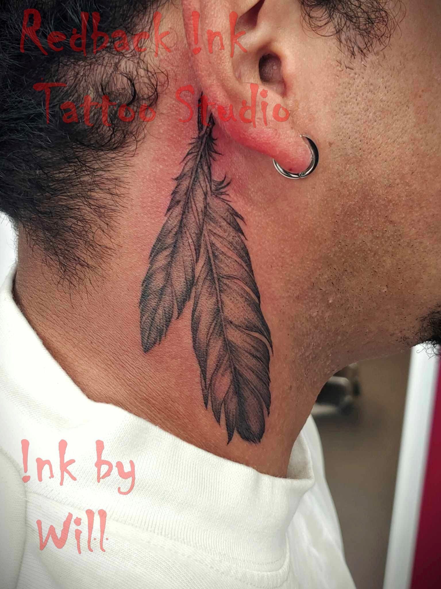 Tattoo of two gray feathers on a person's neck, near their ear.