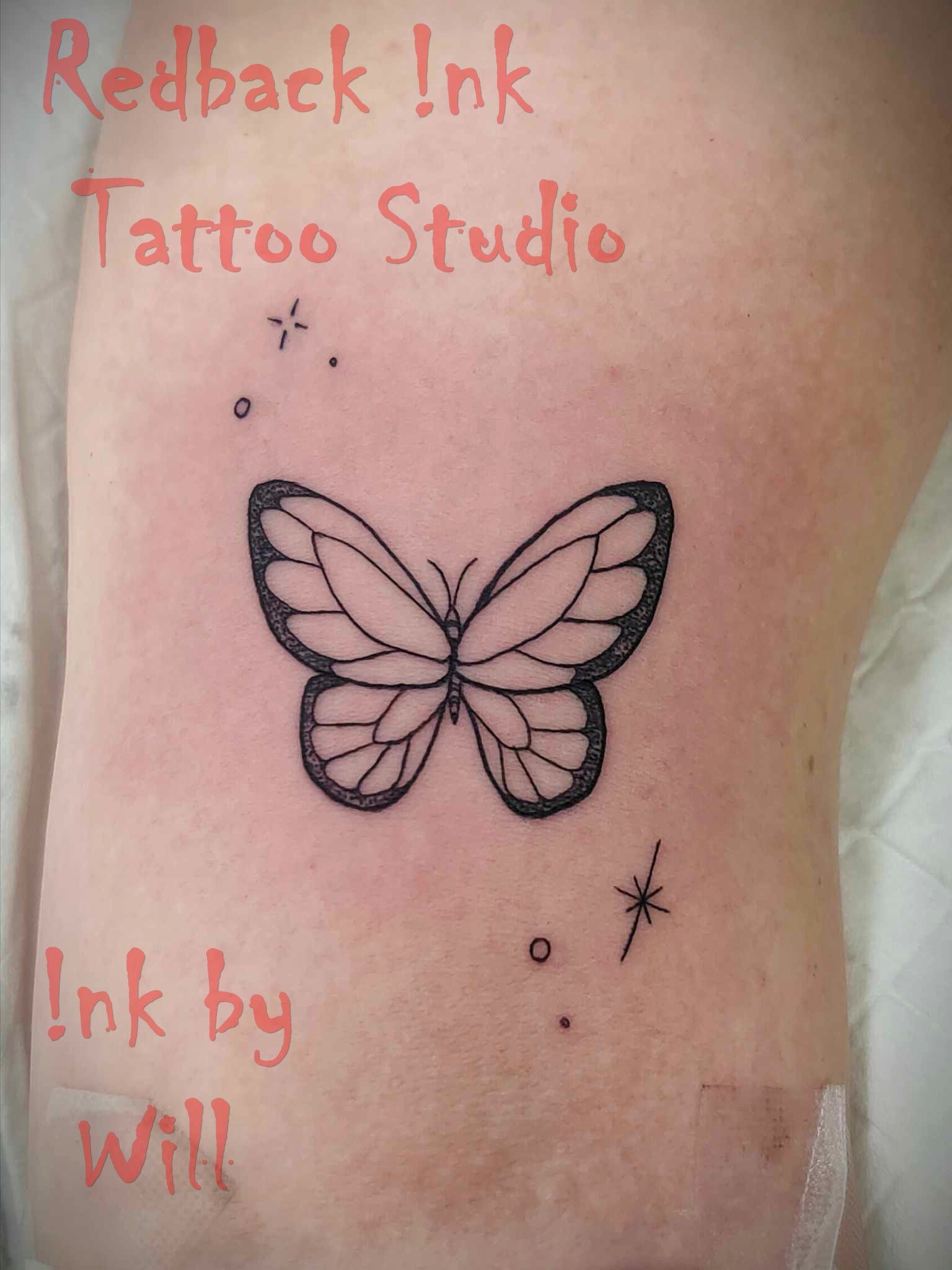 Black butterfly tattoo on skin with small stars. Studio logo.