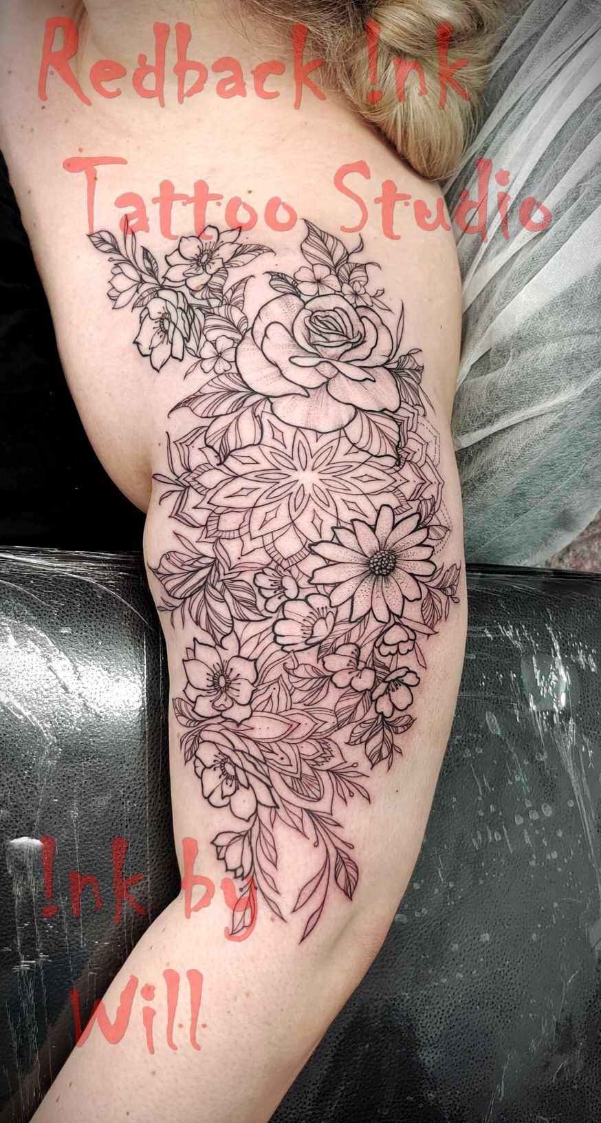 Black outline floral tattoo on a person's arm, designed by Redback Ink Tattoo Studio, by Will.
