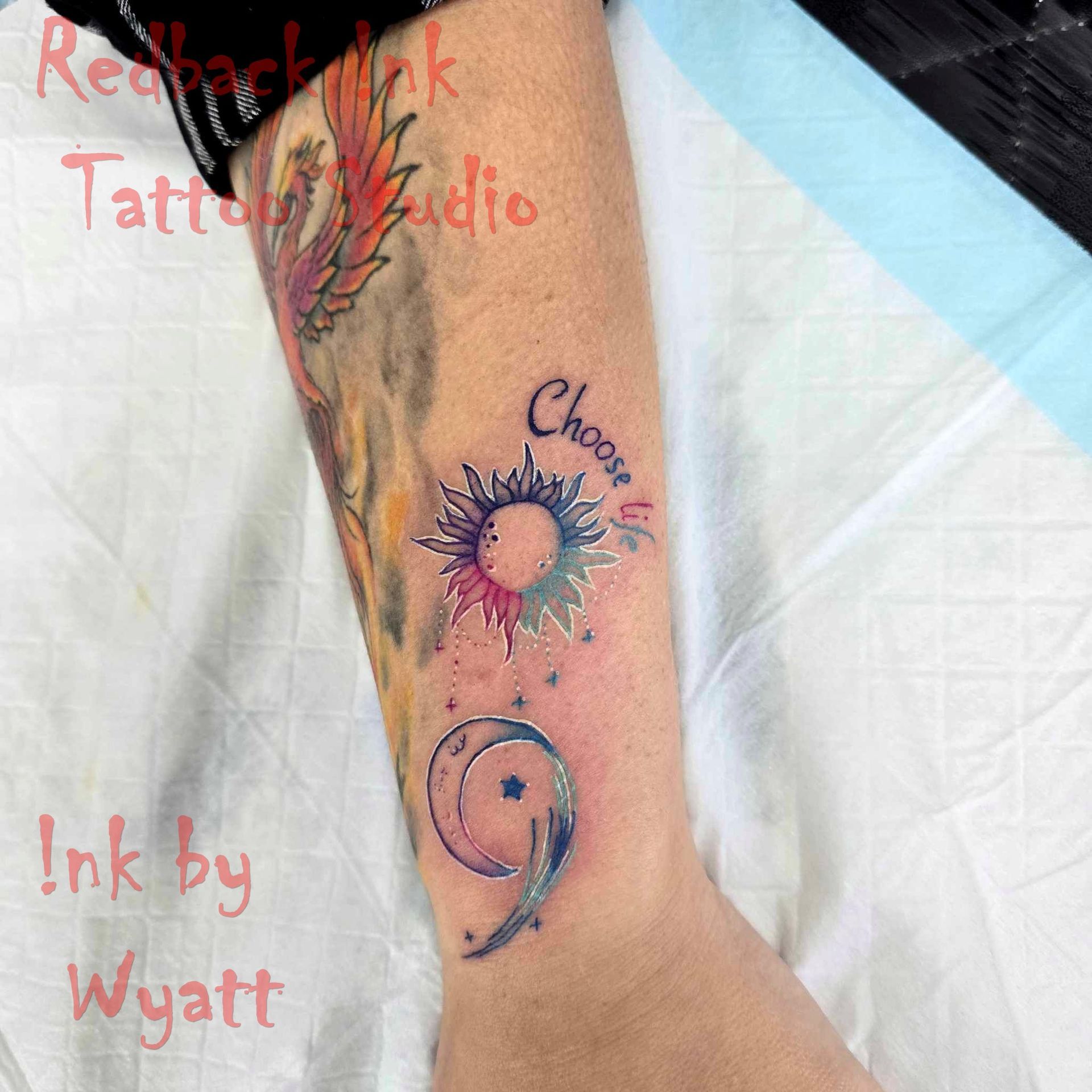 Tattoo on arm: colorful sun with 