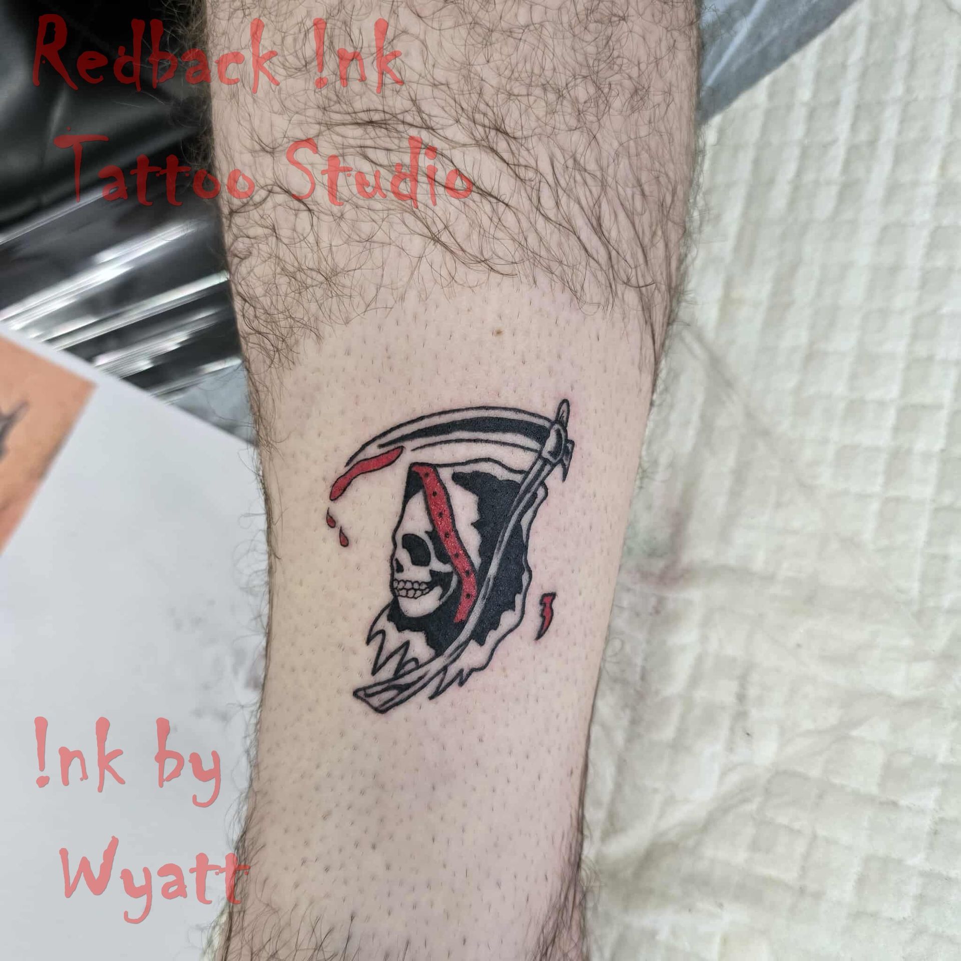 Grim Reaper tattoo on arm, black and red ink, skull with scythe, studio setting — Redback !nk Tattoo Studio in Kawana, QLD