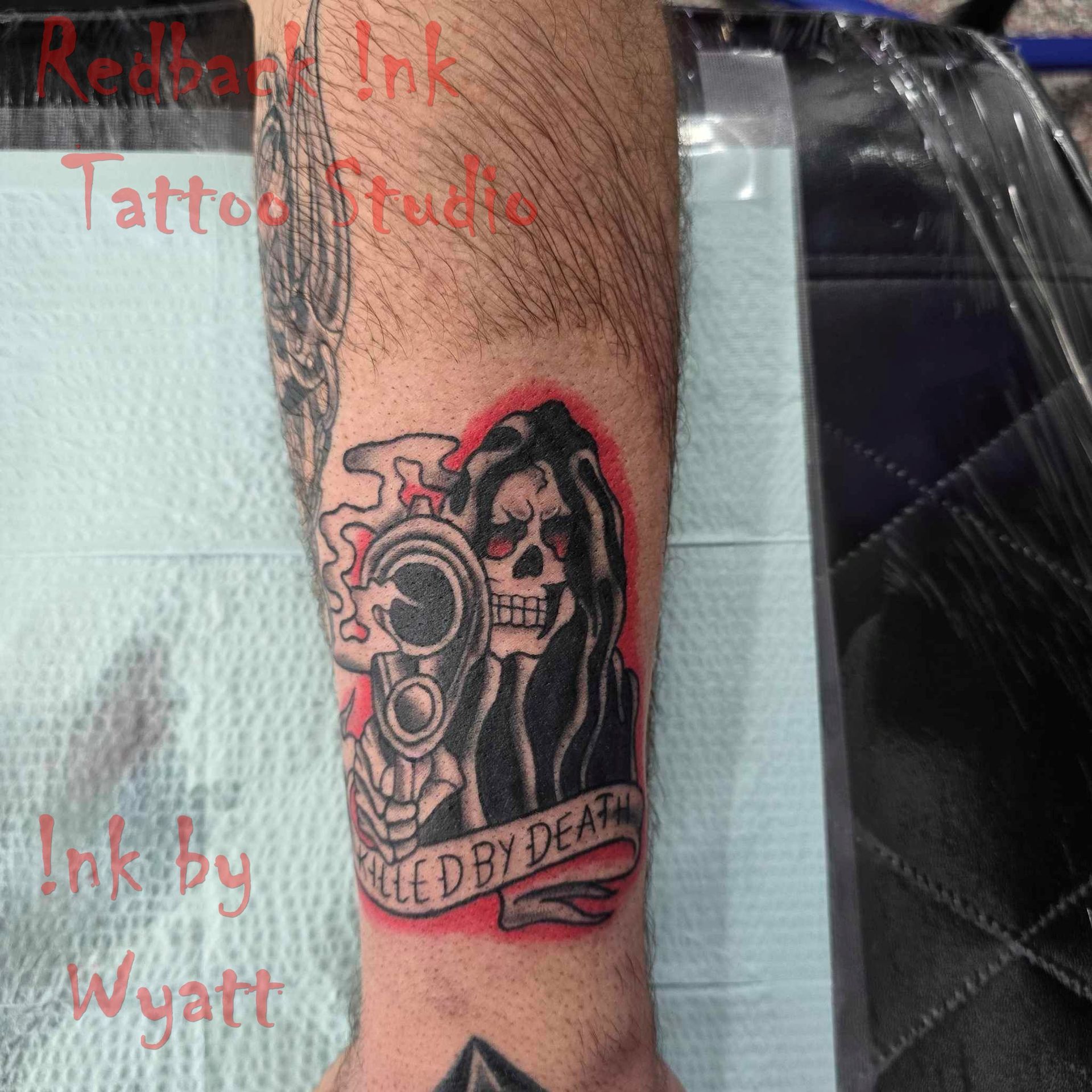 Grim Reaper tattoo holding a gun, red outline, banner reads 