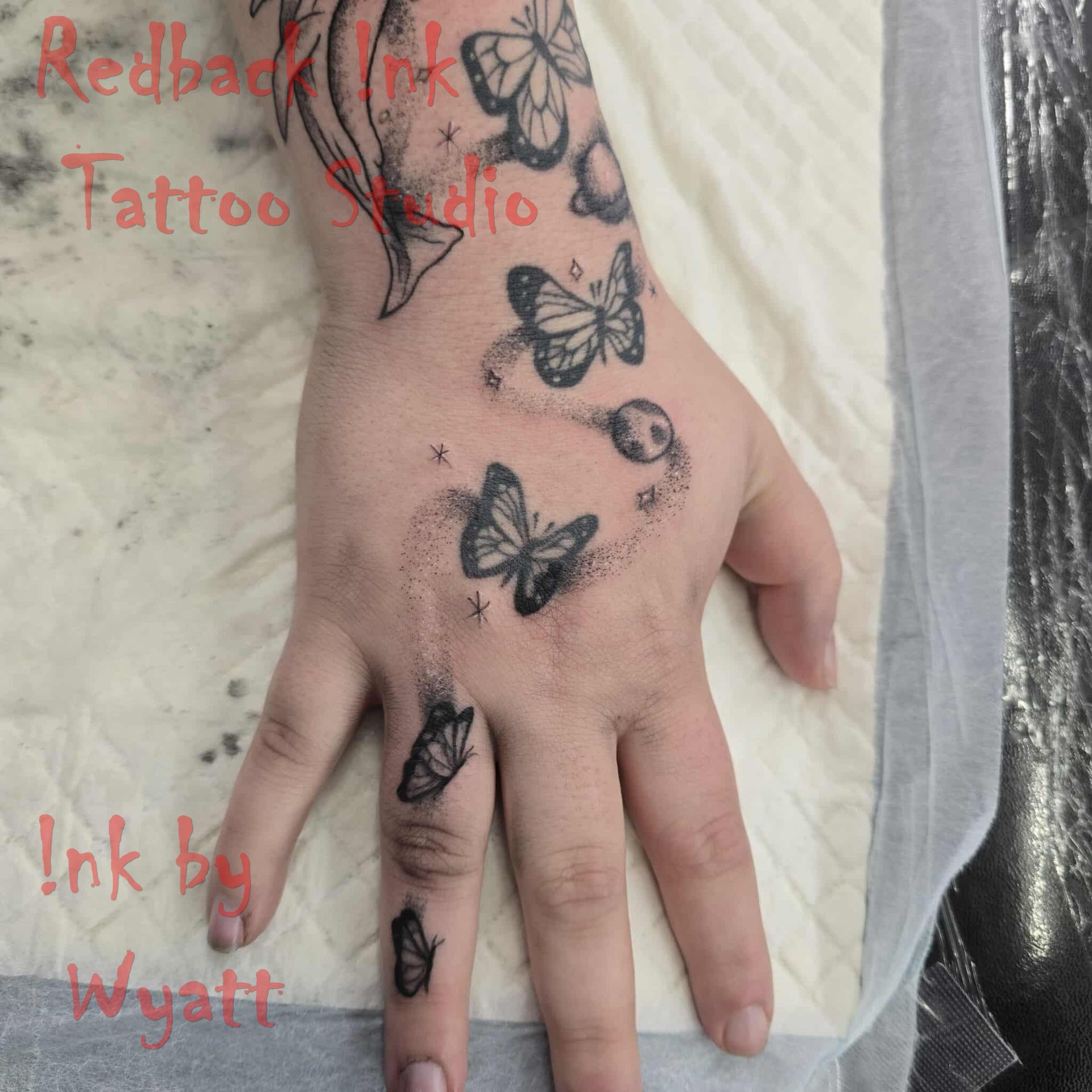 Hand tattoo of butterflies and planets. — Redback !nk Tattoo Studio in Kawana, QLD