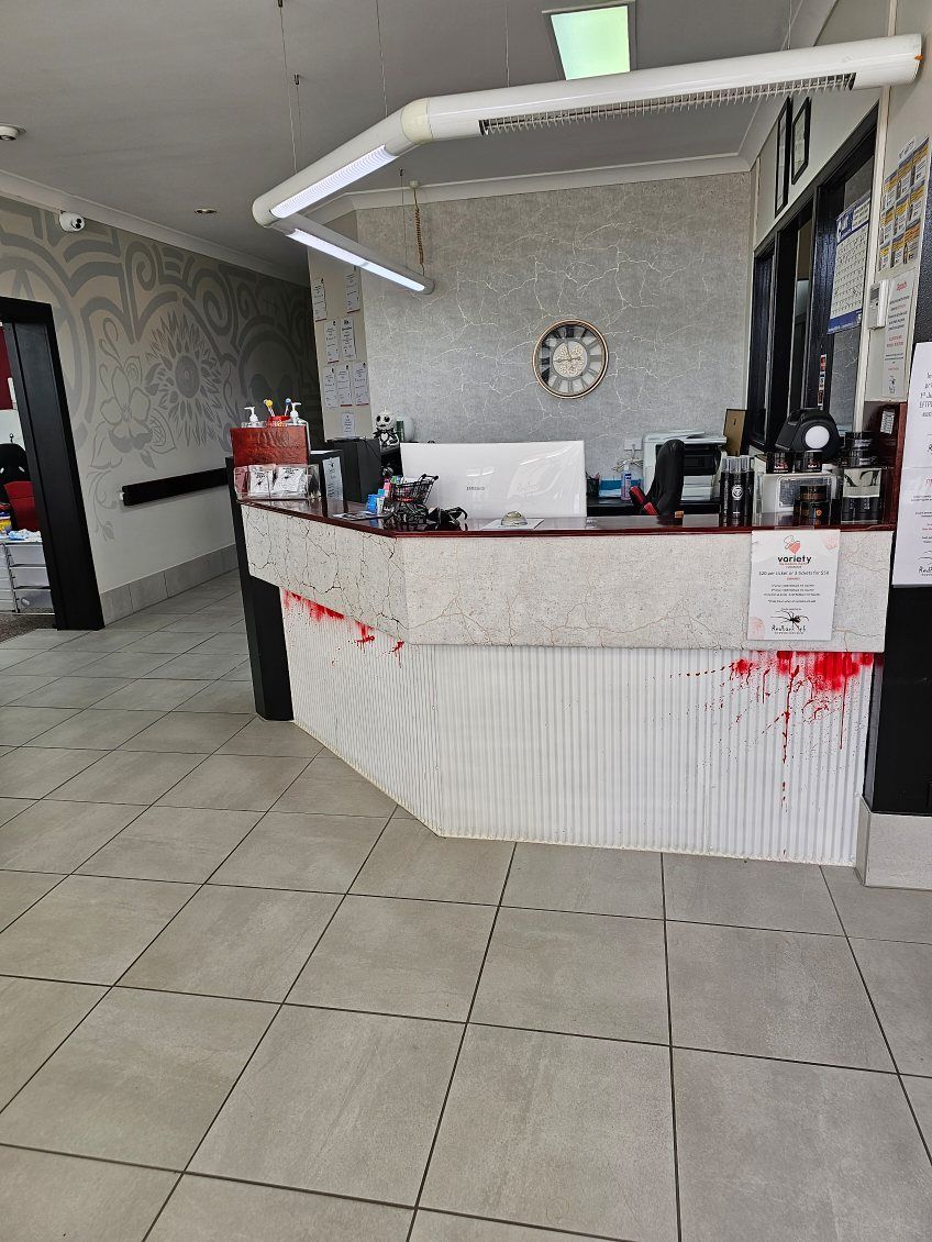 Reception desk with white and red front, under bright lighting — Redback !nk Tattoo Studio in Kawana, QLD