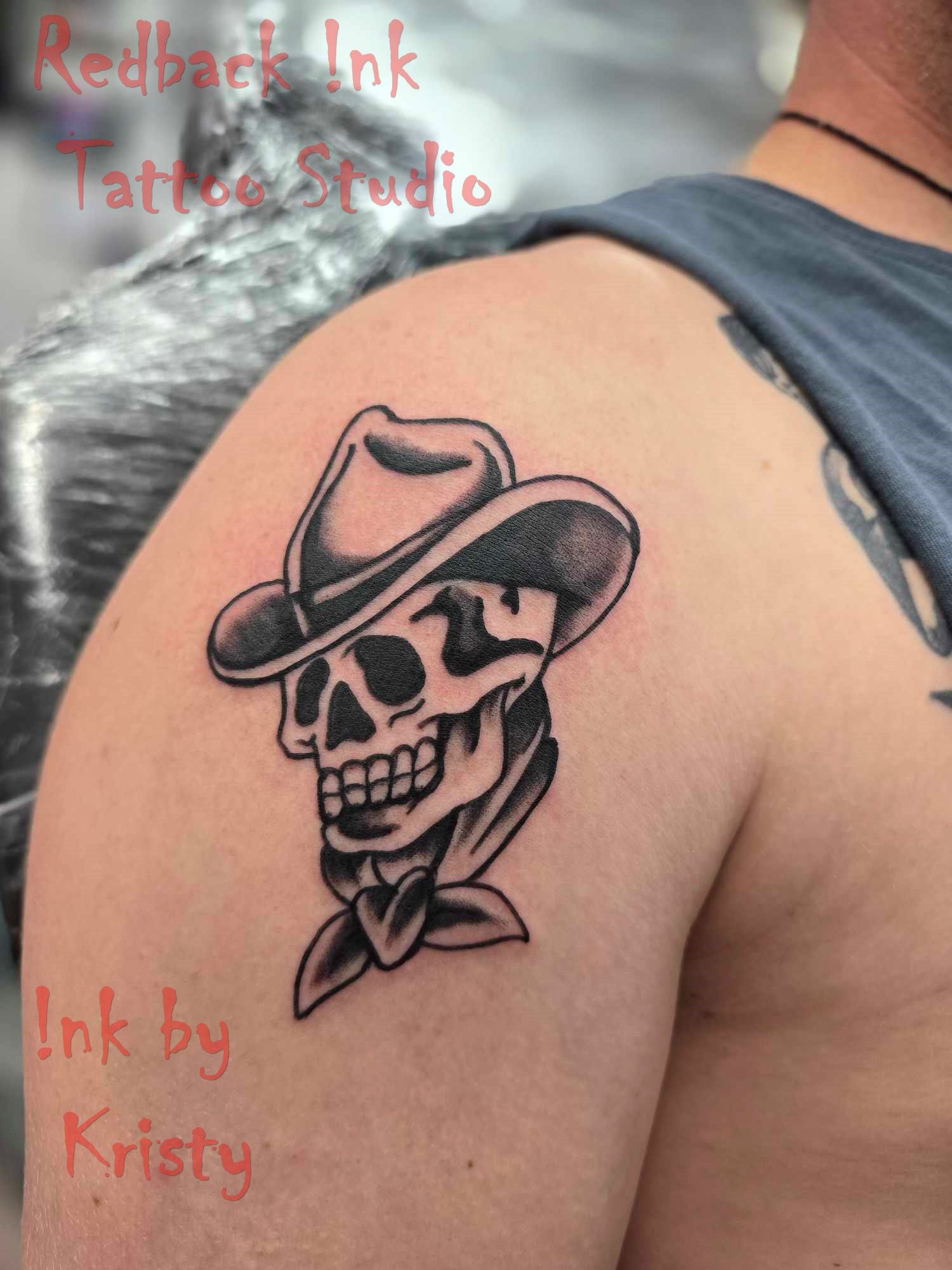 Cowboy skull tattoo in black ink on a person's shoulder. The skull wears a hat and a bandana — Redback !nk Tattoo Studio in Kawana, QLD