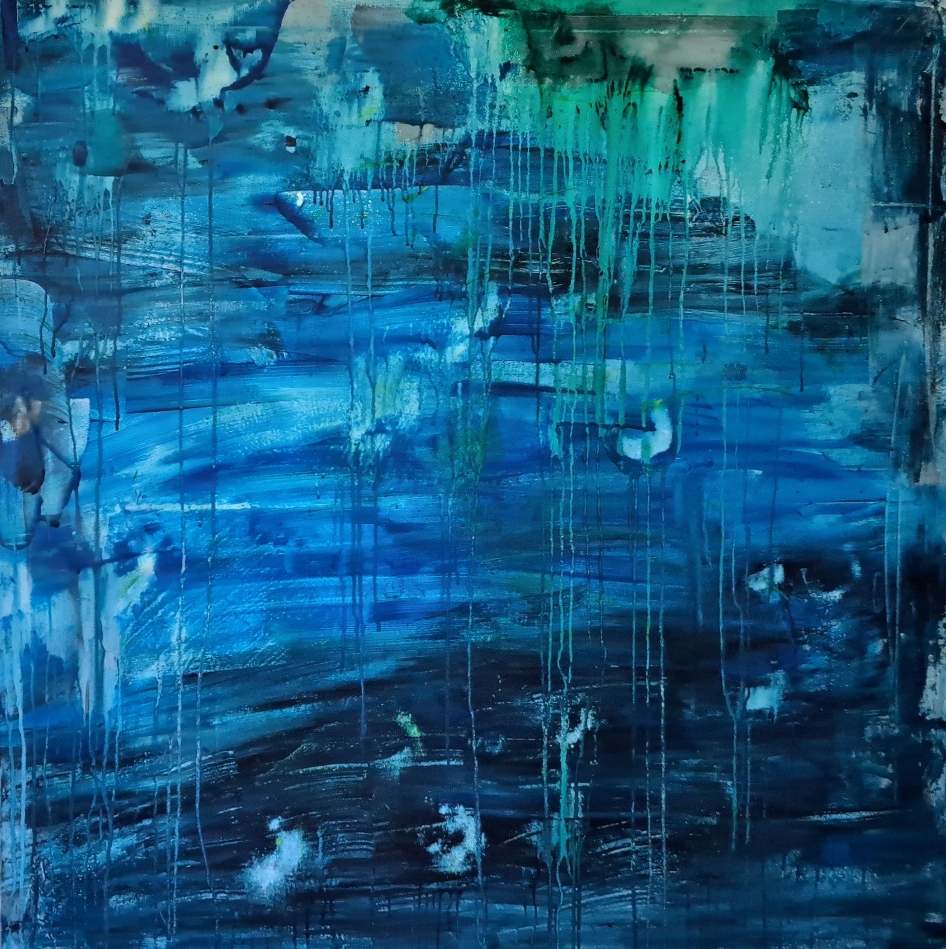 A close up of a blue and green painting on a wall.