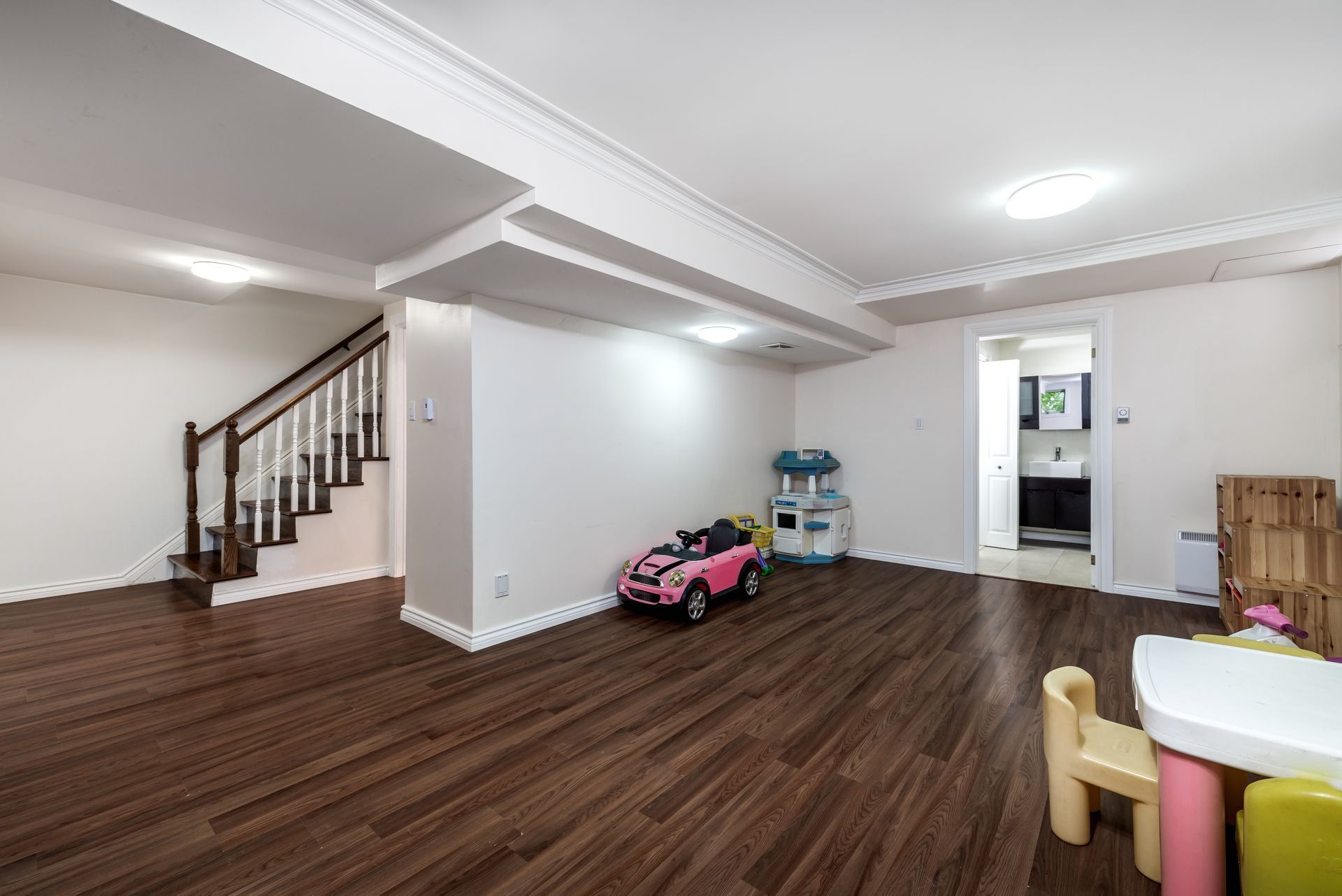 There is a pink toy car in the middle of the room.