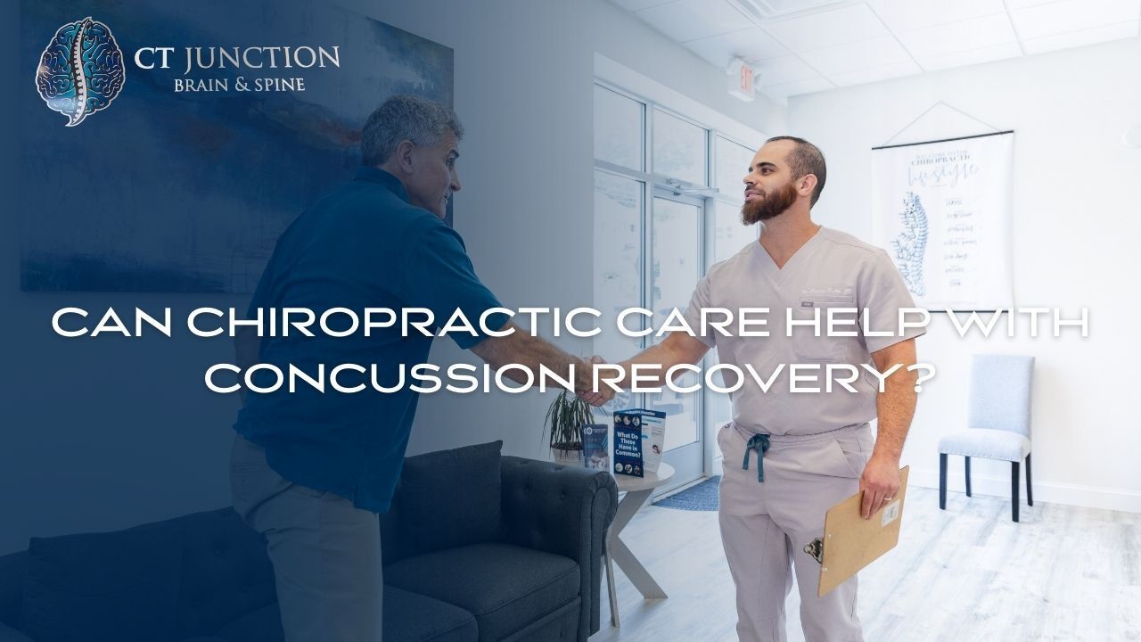 A chiropractor shaking hands with a patient inside a clinic, discussing concussion recovery.