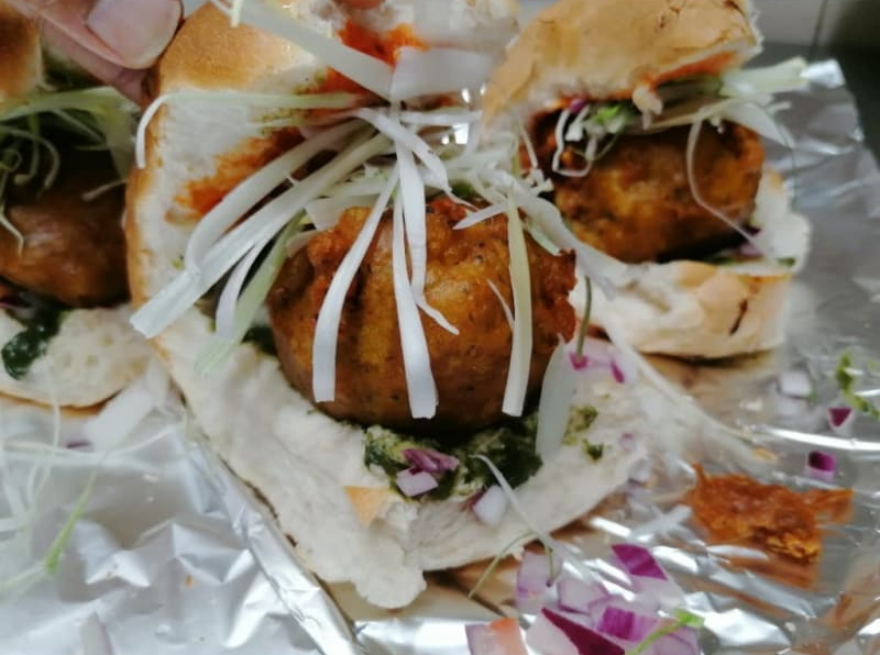 A close up of a sandwich on a piece of tin foil.