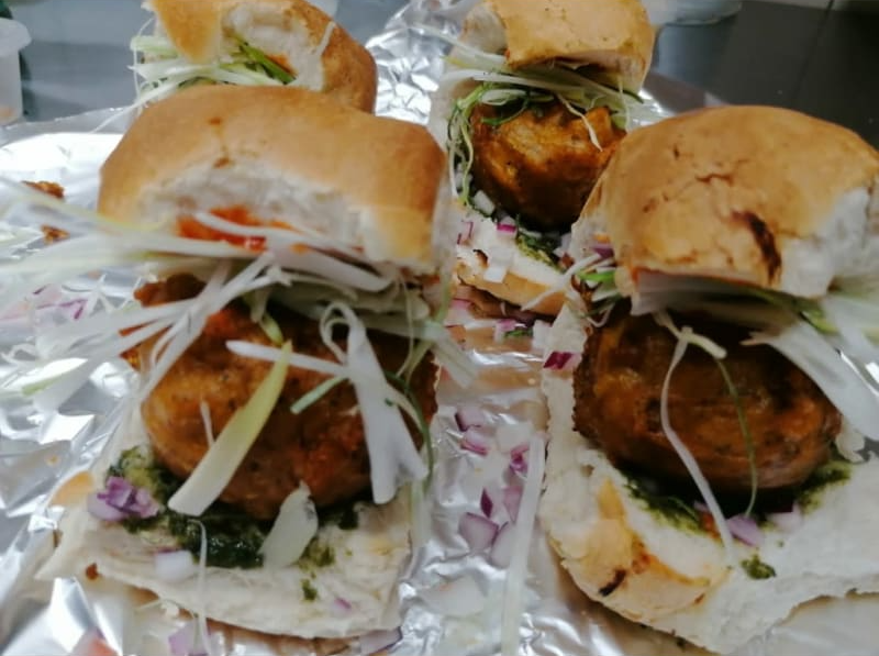 A bunch of sandwiches are sitting on a piece of tin foil.