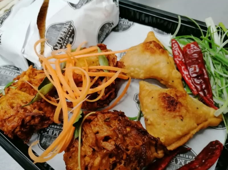 A tray of food with a piece of paper that says ' curry ' on it