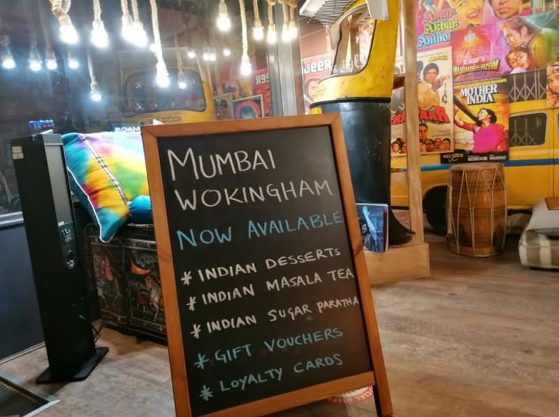 A sign that says ' mumbai wokingham now available ' on it