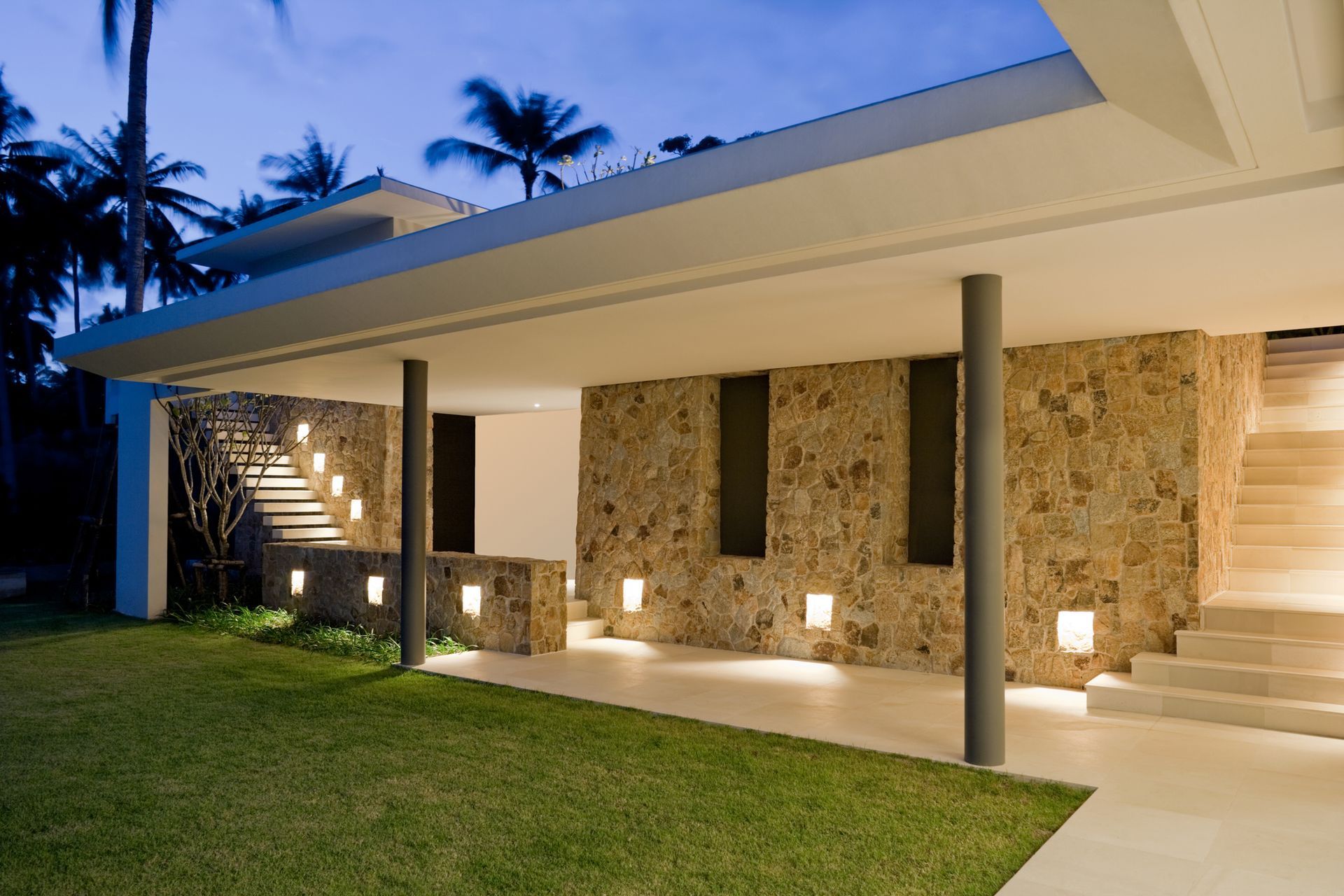 A house with a stone wall and stairs leading up to it