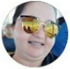 Uma mulher usando óculos escuros está sorrindo em um círculo.
