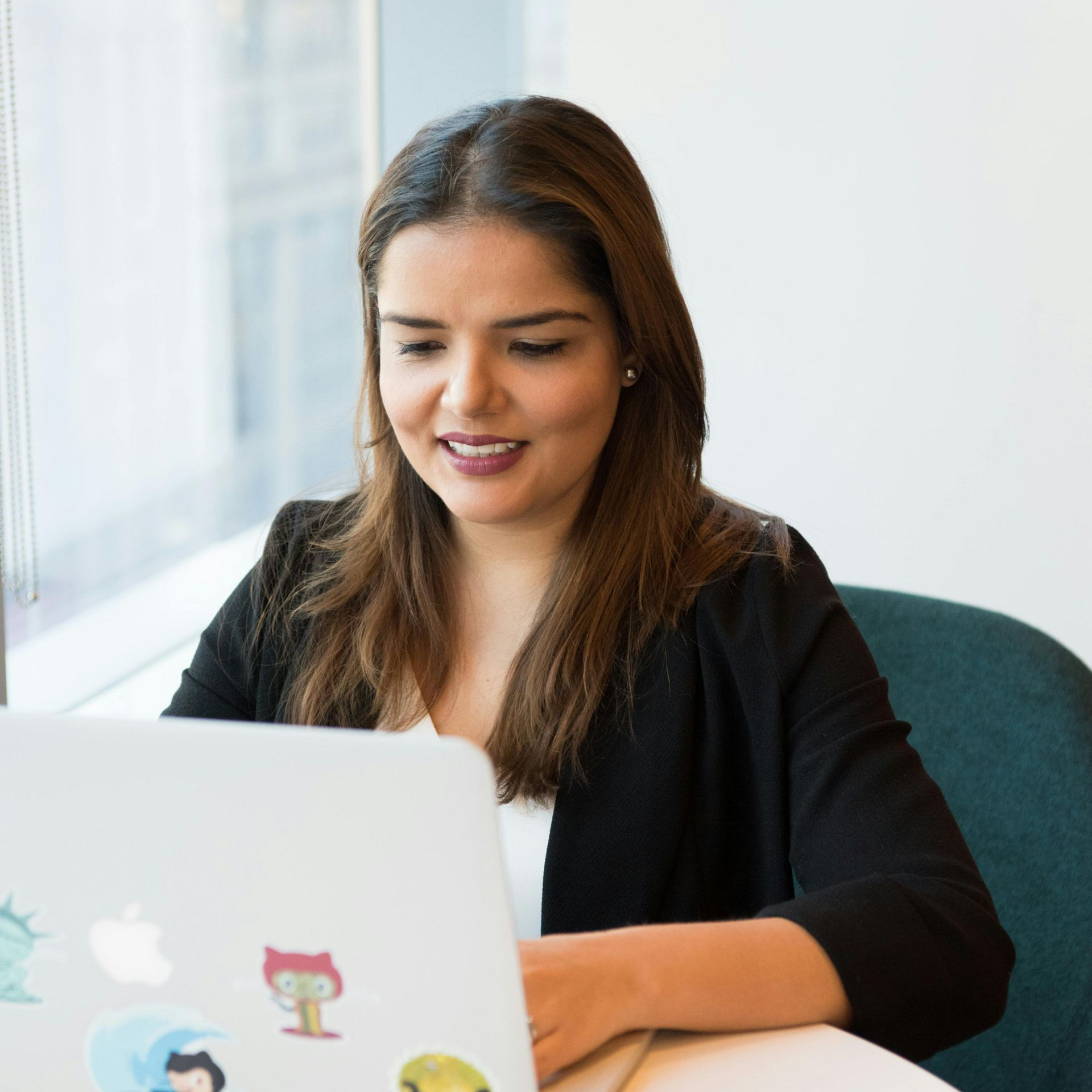 Friends and a small dog enjoying a picnic in a park. They are seated on a blanket, laughing and talking in the sunlight.