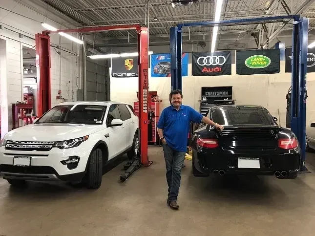 Inside of our garage with a white vehicle and black car | AutoImports of Denver