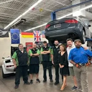 Our team posed inside garage | AutoImports of Denver