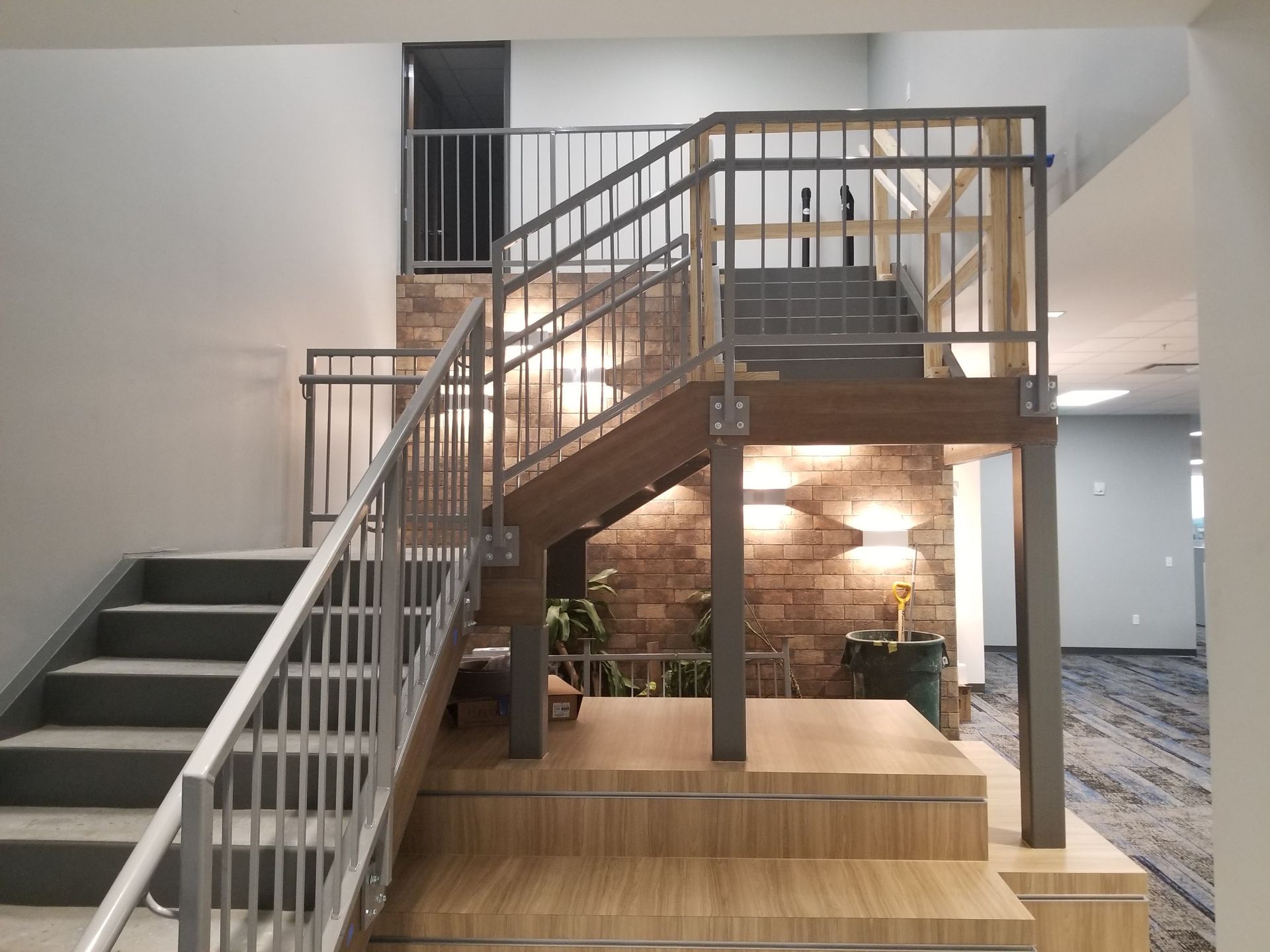 A staircase with a metal railing and wooden steps in a building.