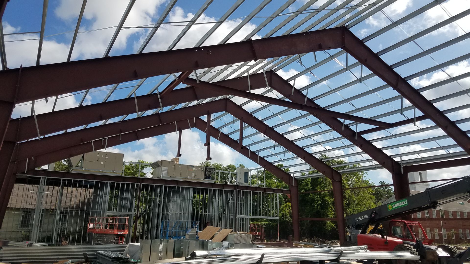 A large metal structure is being built with a crane in the background.