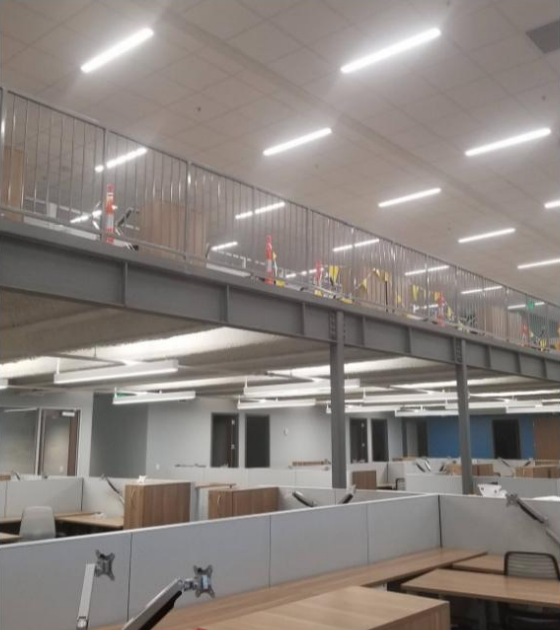 A large office with cubicles and a balcony