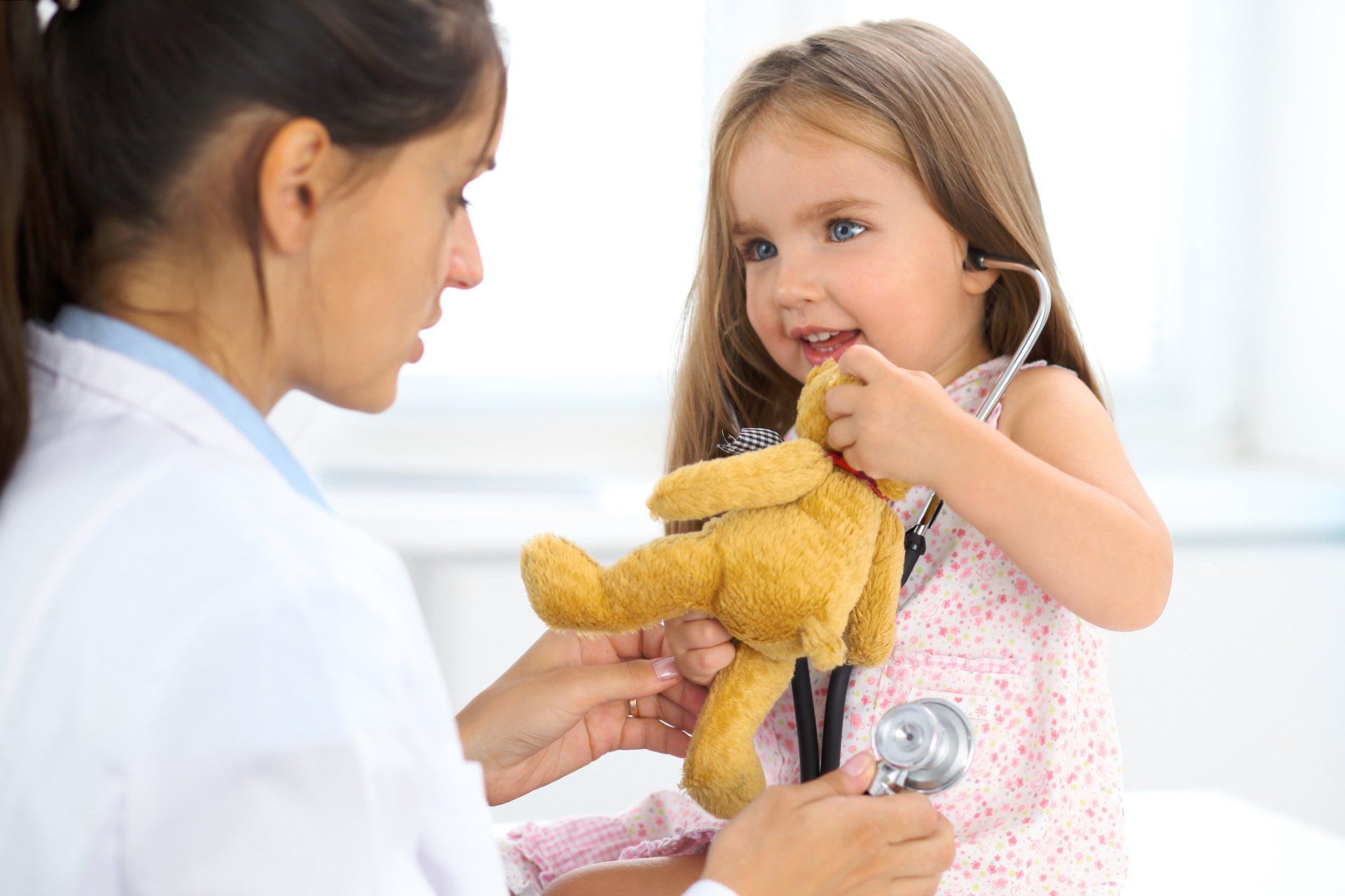 Doctor using a stethoscope on a female child
