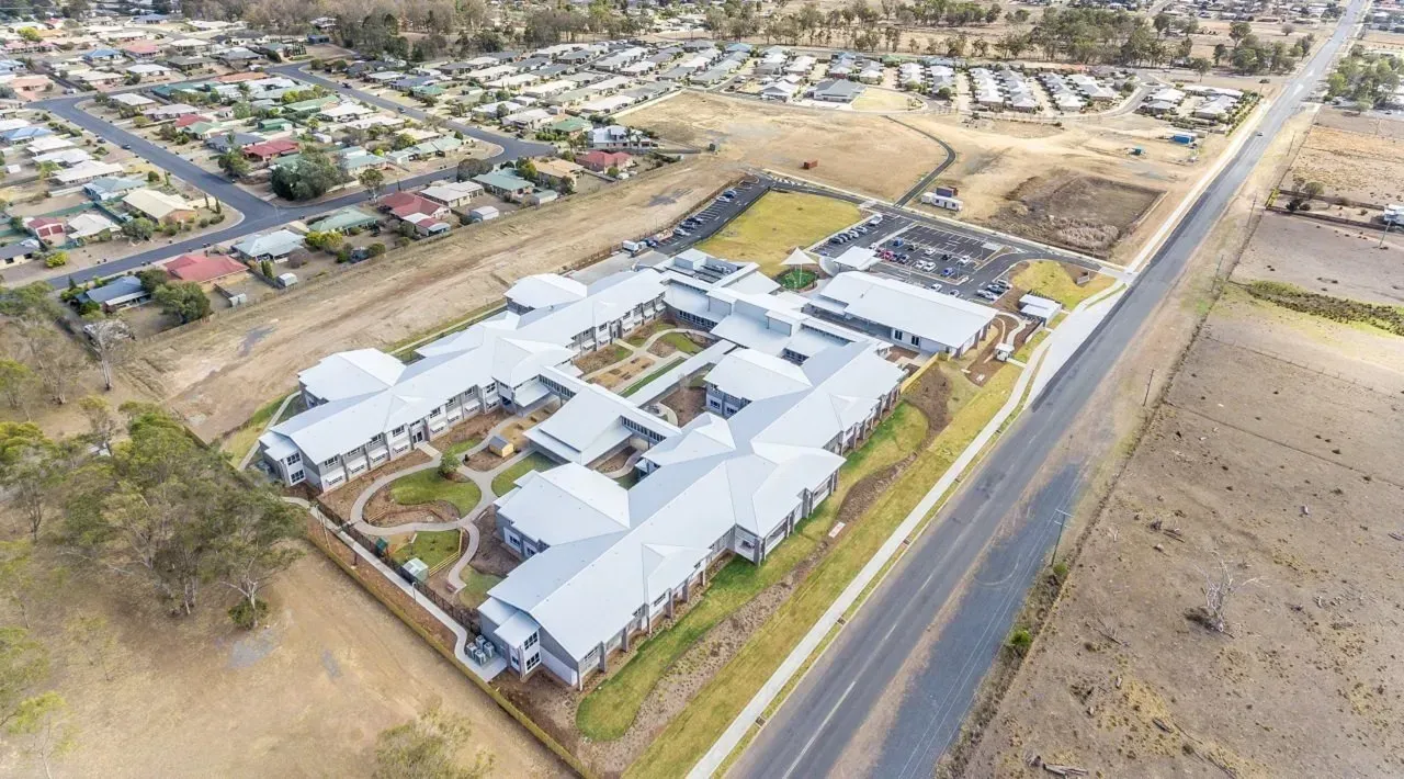An aerial view of a large building next to a road.