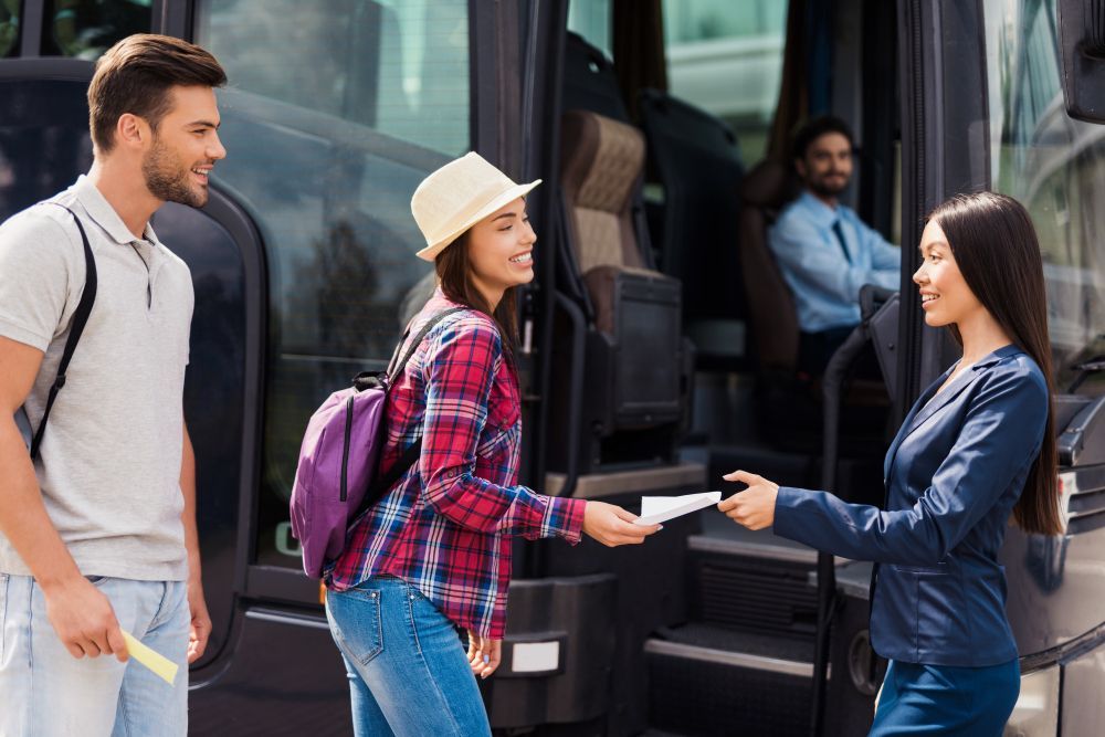 Pessoas embarcando em um ônibus; uma mulher verifica a passagem de um passageiro enquanto outro espera.