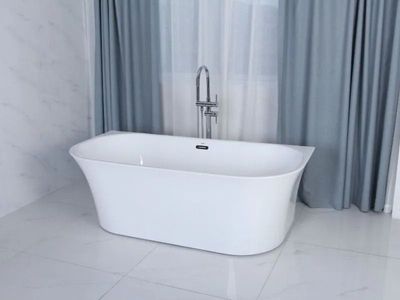 A white, oval freestanding bathtub with a silver floor-mounted faucet, set against blue curtains and marble-tiled walls.