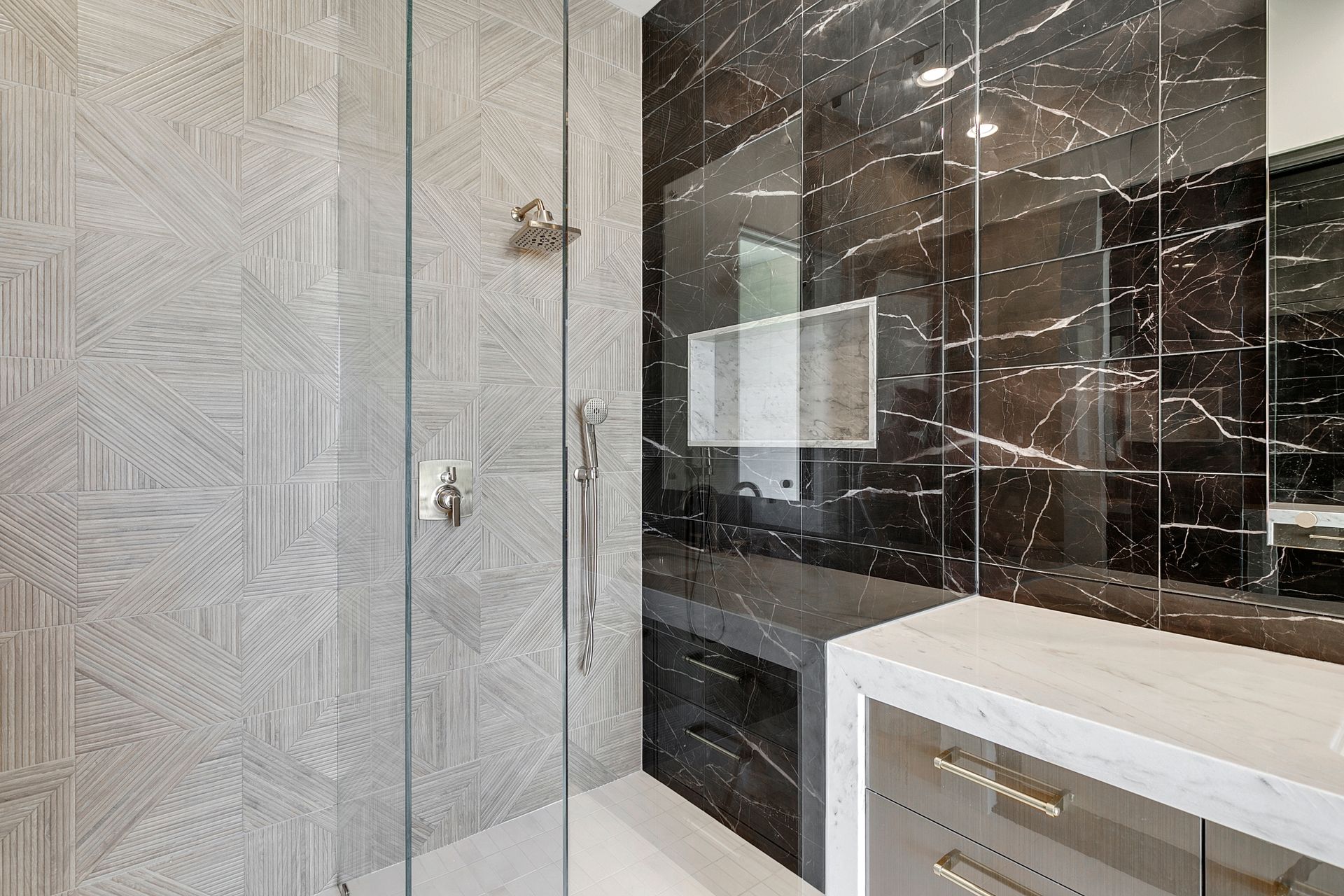 Modern bathroom with patterned tile, dark marble wall, and white vanity with mirror and sink