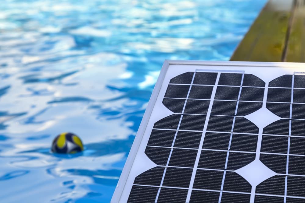 A Solar Panel is Sitting Next to a Swimming Pool — Intouch Pools & Spas in Forster, NSW