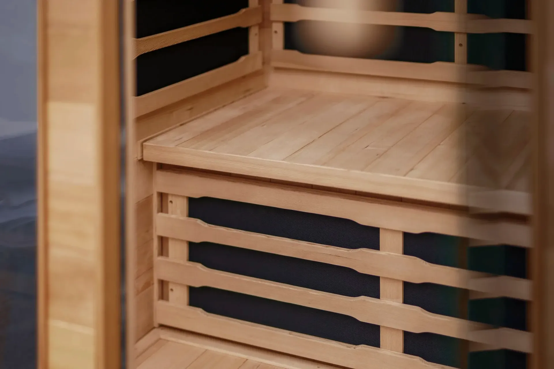Wooden sauna interior with a bench and dark panels. — Intouch Pools & Spas in Forster, NSW
