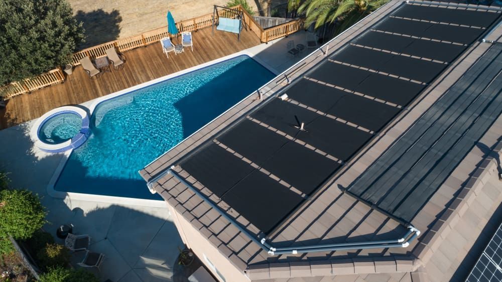 An Aerial View of a Swimming Pool With Solar Panels on the Roof — Intouch Pools & Spas in Forster, NSW