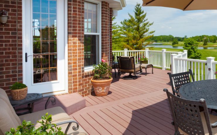 An inviting residential deck in Tempe, Arizona, with outdoor seating, lush greenery, and a classic brick wall on a sunny day.