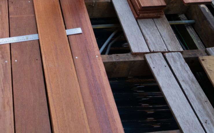 Close-up of wooden deck boards being measured and repaired, showcasing the deck maintenance process in Tempe, Arizona.