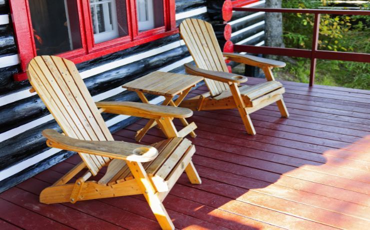 Traditional wooden Adirondack chairs on a redwood-stained porch, providing a rustic relaxation spot at a home in Tempe, Arizona.