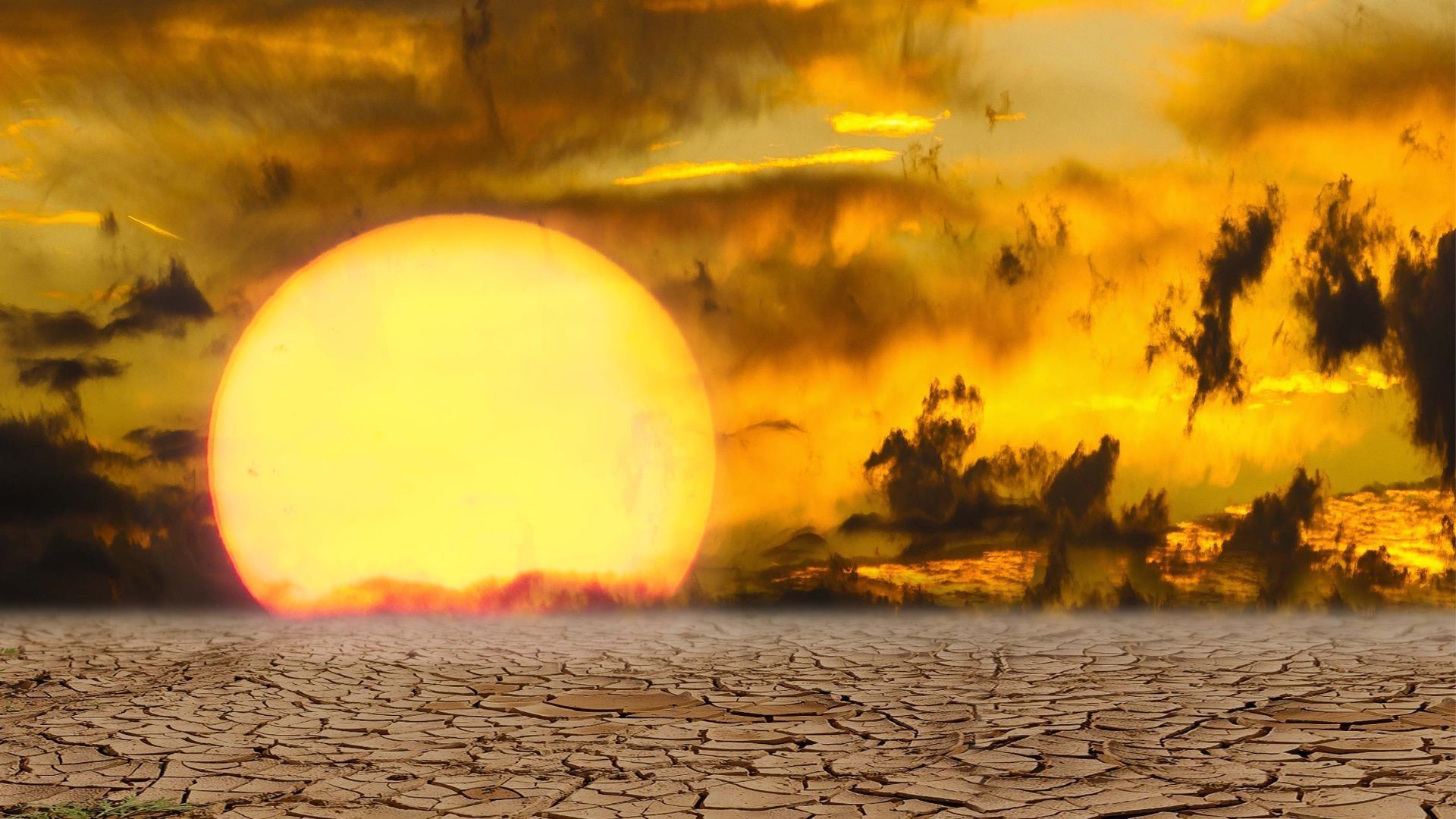 Intense sunset over cracked, dry desert land depicting extreme heat in Tempe, AZ.