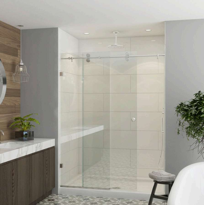 Modern bathroom with glass shower, white tile, and wood vanity.