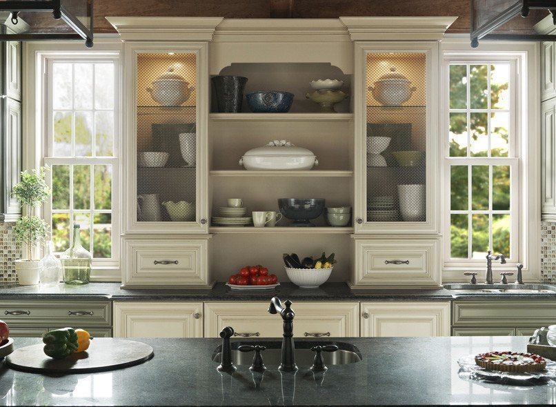 Kitchen with cream-colored cabinets, a dark countertop, and a built-in hutch with display items.