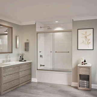 Bathroom with a white tub, glass shower door, wooden vanity and side table, and gray walls.