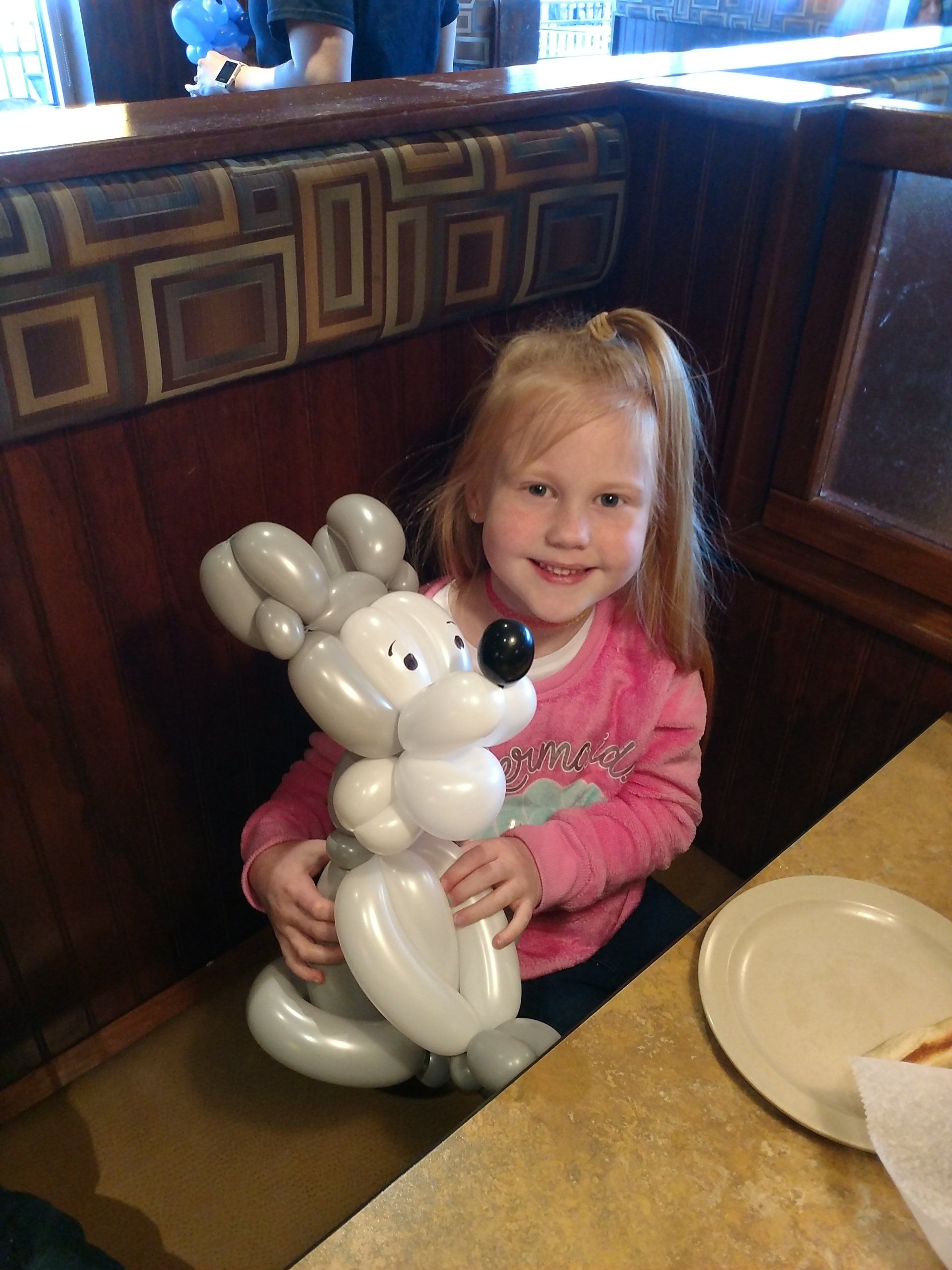 a little girl holding a balloon bunny