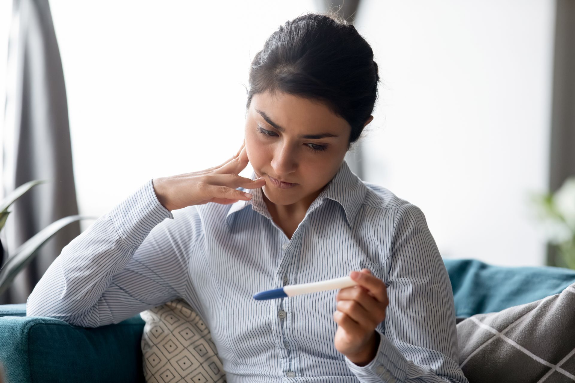 A woman is looking at a pregnancy test.
