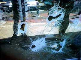 A Person Is Standing In Front Of A Broken Glass Window — Home Tint Sunshine Coast Window Tinting In Maroochydore, QLD