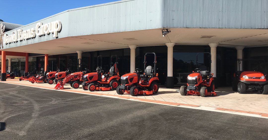 A Row Of Lawn Mowers Are Parked In Front Of A Building — Home Tint Sunshine Coast Window Tinting In Maroochydore, QLD