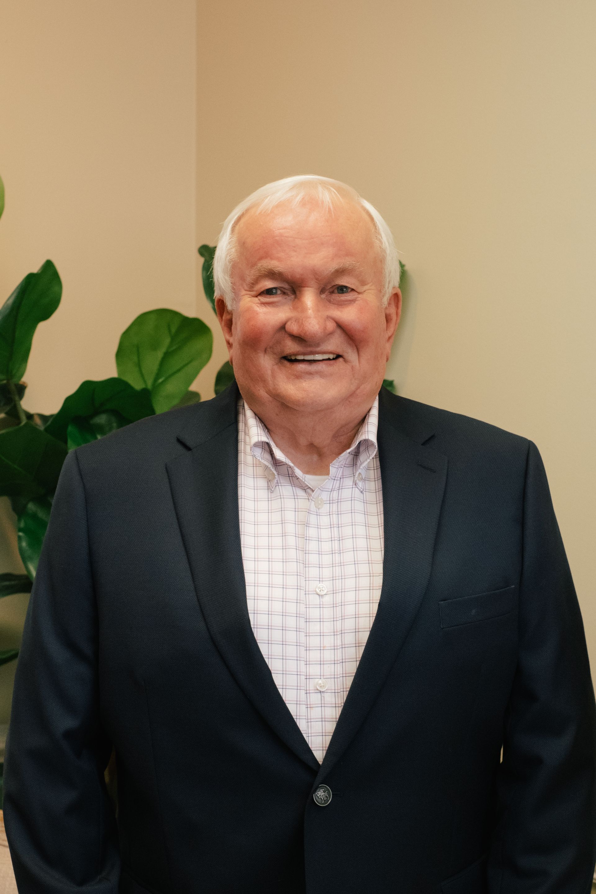 A man in a suit and striped shirt is smiling for the camera.