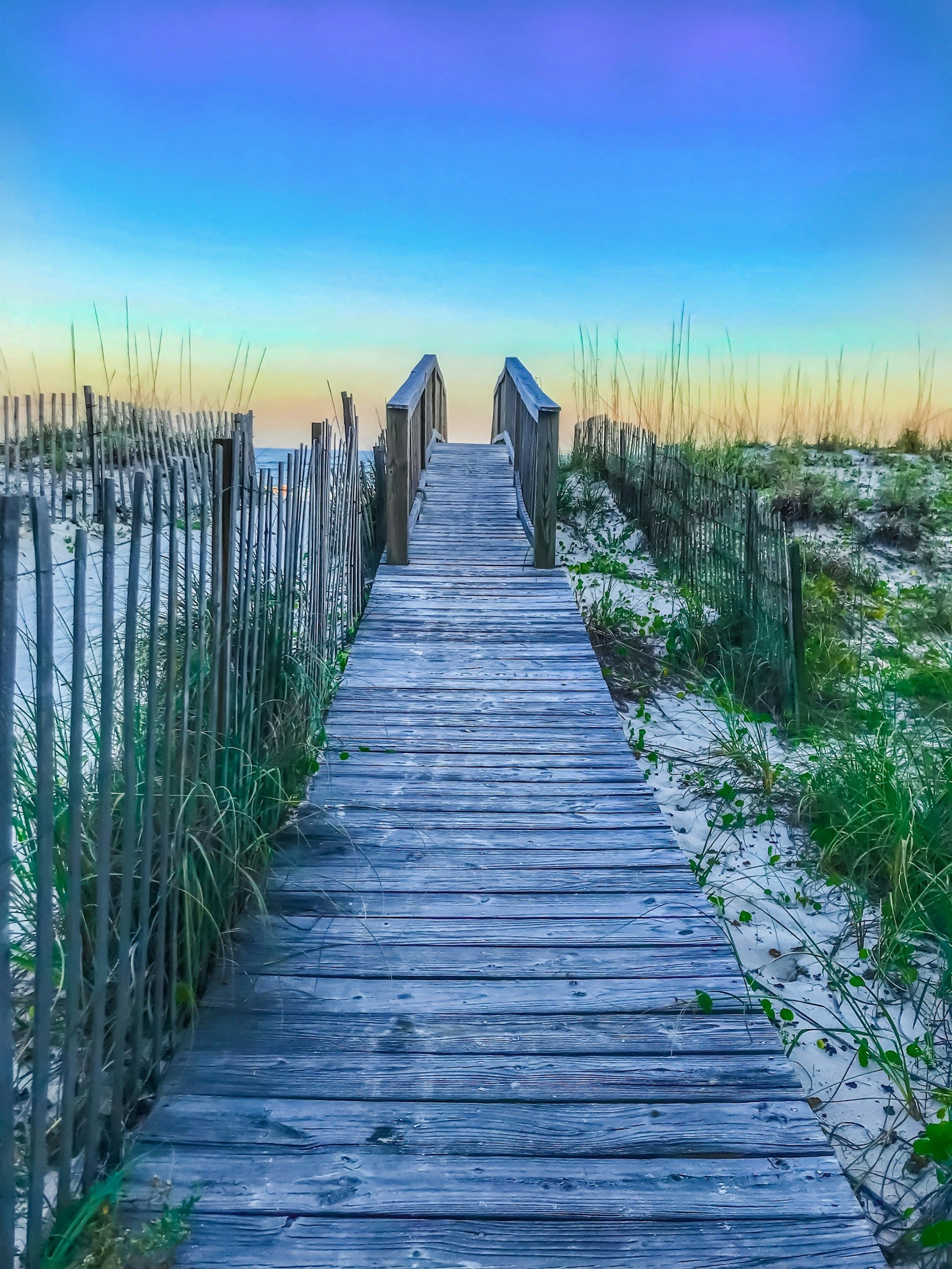 There is a wooden walkway leading to the beach.