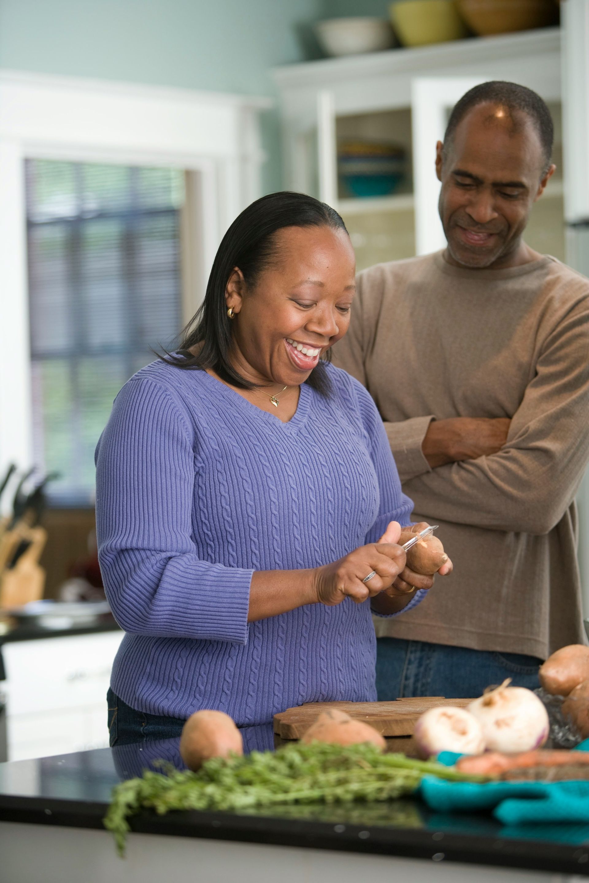 A woman is eating an ice cream cone and smiling.